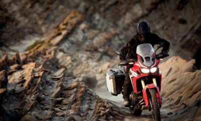 Με την αγορά Honda Africa Twin δώρο το πακέτο εξοπλισμού Travel Pack Η εταιρεία Αδελφοί Σαρακάκη Α.Ε.Β.Μ.Ε. Επίσημος Εισαγωγέας-Διανομέας Honda moto προσφέρει την Africa Twin με δώρο το πακέτο εξοπλισμού Travel Pack, αξίας 950€. Το πακέτο εξοπλισμού TRAVEL PACK περιλαμβάνει: • Τριπλέτα βαλιτσών: κεντρική βαλίτσα 35lt, πλαϊνές βαλίτσες 30 και 40 lt • Ψηλός ανεμοθώρακας • Κεντρικό σταντ • Σχάρα κεντρικής βαλίτσας • Κιτ κλειδαριάς κεντρικής βαλίτσας • Μαξιλάρι πλάτης συνεπιβάτη Το πακέτο Travel Pack κάνει τα ταξίδια με την Africa Twin ακόμη πιο άνετα, εύκολα και με μεγαλύτερη ασφάλεια. *Η προσφορά ισχύει για περιορισμένο αριθμό μοτοσυκλετών. Λίγα λόγια για την Honda Africa Twin: Η νέα CRF1000L Africa Twin κληρονομεί και διαιωνίζει το πνεύμα των ένδοξων προγόνων της που έγιναν διάσημες με το σλόγκαν “go anywhere” (‘Πάμε Παντού’). Χρησιμοποιεί έναν καινοτόμο και ισχυρό, εν σειρά δικύλινδρο κινητήρα σε ελαφρύ, ευέλικτο πλαίσιο και δηλώνει έτοιμη για αληθινή περιπέτεια εντός και εκτός δρόμου, είτε διασχίζοντας ηπείρους ή σε καθημερινές αστικές διαδρομές. Αρχή όλων είναι ο κινητήρας που πρέπει να λειτουργεί σε συνθήκες εκτός δρόμου καθώς και σε μακρινά ταξίδια και σε όλες τις ενδιάμεσες οδηγικές συνθήκες. Ο εν σειρά δικύλινδρος κινητήρας 998cc της CRF1000L Africa Twin βασίζεται στις αγωνιστικές CRF250R/450R της Honda, υιοθετώντας την ίδια τετραβάλβιδη σχεδίαση κεφαλής Unicam για συμπαγείς συνολικές διαστάσεις. Συμπαγής, ελαφρύς και ισχυρός. Ο εν σειρά, δικύλινδρος της CRF1000L Africa Twin αποδίδει μέγιστη ισχύ 70Kw (95,2hp) στις 7.500rpm, και ροπή 98Nm στις 6.000rpm. Το ελαφρύ, εξατάχυτο μηχανικό κιβώτιο χρησιμοποιεί την ίδια σχεδίαση φουρκετών που γνωρίζουμε από την CRF250R/450R για διασφάλιση θετικών αλλαγών και εφοδιάζεται με αλουμινένιο μονόδρομο συμπλέκτη ολίσθησης / υποβοήθησης (Assist Slipper Clutch). Επιπλέον του στάνταρ μοντέλου, διατίθενται δύο ακόμα εκδόσεις: η πρώτη με ABS και multiple mode Honda Selectable Torque Control (HSTC), και η δεύτερη με το μοναδικό Dual Clutch Transmission της Honda (τώρα με νέα λειτουργία off-road), ABS και HSTC. Σε μοντέλα με ABS, ο αναβάτης μπορεί να απενεργοποιεί το ABS για το πίσω φρένο, κάτι που του επιτρέπει να μπλοκάρει τον πίσω τροχό σε συνθήκες off road. Ο χρήστης δύναται να επιλέξει από τέσσερα επίπεδα ελέγχου στο Honda Selectable Torque Contol: Επίπεδο 1, 2, 3 και Off. Ο βαθμός παρέμβασης μειώνεται όσο τα επίπεδα αυξάνονται, ώστε να επιτρέπεται μεγαλύτερη ολίσθηση του πίσω τροχού. Η μοναδική έκδοση DCT (Dual Clutch Transmission) περιλαμβάνει το στάνταρ manual mode (χειροκίνητη λειτουργία) – που επιτρέπει στον οδηγό να αλλάζει σχέσεις από το αριστερό γκριπ – και δύο automatic modes (αυτόματες λειτουργίες). Το D mode προσφέρει την καλύτερη ισορροπία οικονομίας καυσίμου και άνεσης στο ταξίδι, ενώ το S mode έχει αναβαθμιστεί με σκοπό τις ανώτερες σπορ επιδόσεις, με τρία διαφορετικά σχέδια/μοτίβα αλλαγών. Ασφαλώς, για την CRF1000L Africa Twin, το DCT είναι ρυθμισμένο ώστε να λειτουργεί σε περιβάλλον off-road , κάτι που αναβαθμίζεται με το μπουτόν G. Πιέζοντας το μπουτόν G σε οποιοδήποτε πρόγραμμα οδήγησης μεταβάλλεται ο έλεγχος του συμπλέκτη για να επιτυγχάνεται πιο άμεση μετάδοση κίνησης. Το ατσάλινο πλαίσιο της CRF1000L Africa Twin προσφέρει την τέλεια ισορροπία ευστάθειας στις υψηλές ταχύτητες – ακόμα και υπό πλήρες φορτίο – σε συνδυασμό με γνήσιες off-road ικανότητες, παντρεύοντας τη δύναμη με την ευελιξία. Η συγκέντρωση μαζών στο κέντρο – με στοιχεία όπως η μπαταρία που τοποθετείται στο πίσω μέρος της κυλινδροκεφαλής – συμβάλλει στο χαμηλό κέντρο βάρους και αυξάνει την ευελιξία.