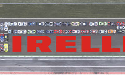 Τη Monza επέλεξε η Pirelli για μία αναβίωση της απεικόνισης του λογοτύπου της που χρονολογείται από το 1978, μήκους 80 m και ύψους 18 m. Στο εγχείρημα συμμετείχαν 41 αυτοκίνητα, 12 κορυφαίοι κατασκευαστές αυτοκινήτων, πάνω από 150 άνθρωποι και 22.000 ίπποι. Όπως πριν από 40 χρόνια, αξιοσημείωτη ήταν η γκάμα των αυτοκινήτων που συνέθεσαν το λογότυπο: διαφορετικές μάρκες, μοντέλα, κινητήρες, αρχιτεκτονικές και στυλ – αλλά με τα ίδια ελαστικά. Στην αναπαράσταση του λογοτύπου της Pirelli το 1978 συμμετείχαν αυτοκίνητα δρόμου, τα οποία, στη σύγχρονη εκδοχή τους, έχουν αντικατασταθεί από οχήματα GT3 που αγωνίζονται στην κατηγορία Blancpain GT: το κορυφαίο πρωτάθλημα με αγωνιστικά αυτοκίνητα βασισμένα σε μοντέλα δρόμου, εφοδιασμένα αποκλειστικά με ελαστικά της Pirelli. Συνολικά 41 αυτοκίνητα διαμόρφωσαν το λογότυπο Pirelli στη Monza, την ώρα που ο ήλιος έδυε μετά από μία ημέρα με έντονη δράση στην πίστα. Τα αυτοκίνητα συγκεντρώθηκαν για τη φωτογράφηση στη μεγάλη ευθεία, όπου συνήθως αναπτύσσουν ταχύτητες 280kph. Αυτή τη φορά, στριμώχτηκαν το ένα δίπλα στο άλλο, με μοναδικό ήχο, αυτό των ελαστικών P Zero πάνω στη διάσημη άσφαλτο. Η αρχική ιδέα το 1978 ήταν να συμμετέχουν πολλά και διαφορετικά οχήματα δρόμου διαφόρων κατασκευαστών, για να αναδειχτεί ότι το κοινό χαρακτηριστικό τους ήταν τα ελαστικά Pirelli. Ο φωτογράφος Adrian Hamilton ήταν ο σκηνοθέτης ενώ υπήρξε και μία τηλεοπτική διαφήμιση με τη δημιουργική υπογραφή του Ιταλού σκηνοθέτη Giulio Cingoli, που λανσάρισε το σλόγκαν: “Tyres with a capital P” (Ελαστικά με P κεφαλαίο). Αυτό ήταν και η πρώτη τηλεοπτική διαφήμιση, συνοδεία ενός βίντεο ‘making of’. Μετά από 40 χρόνια, φτάνουμε στο 2018 και το θρυλικό σιρκουί της Monza: μία από τις μακροβιότερες μόνιμες πίστες που εξακολουθούν να χρησιμοποιούνται σε τακτική βάση, η δεύτερη μετά την Indianapolis. Και για μία φορά ακόμα – χάρη στη συνεργασία με τους διοργανωτές του πρωταθλήματος SRO – σχηματίστηκε ένα ακόμα γιγαντιαίο λογότυπο της Pirelli από τα αυτοκίνητα παραταγμένα στην άσφαλτο. Ωστόσο, αντί για μοντέλα δρόμου όπως το 1978, χρησιμοποιήθηκαν προηγμένα GT3 οχήματα που τρέχουν στο πρωτάθλημα Blancpain. Σε αυτό εκπροσωπούνται περισσότεροι κατασκευαστές από οποιαδήποτε κατηγορία, με τη λίστα να περιλαμβάνει τις Aston Martin, Audi, Bentley, BMW, Ferrari, Lamborghini, Lexus, McLaren, Mercedes-AMG, Nissan, Porsche και Jaguar. Η κάθε εταιρία έδωσε το παρών με ένα γράμμα από το λογότυπο Pirelli στη μεγάλη ευθεία, καθώς κάθε μία έχει το μερίδιό της σε έναν κόσμο υψηλού κύρους, όπου η Pirelli είναι ηγέτης της αγοράς. Πολλές από τις εταιρίες χρησιμοποιούν ελαστικά Pirelli αποκλειστικά, με ειδική έγκριση τύπου για αναβάθμιση της δυναμικής συμπεριφοράς κάθε αυτοκινήτου και μεγιστοποίηση της ασφάλειας. Το P Zero είναι ο απόλυτος εκφραστής της στρατηγικής ‘perfect fit’ της Pirelli, από το 1987 που πρωτοεμφανίστηκε, όταν η Ferrari F40 έκανε το ντεμπούτο της με ειδικά ελαστικά Pirelli. Και από την αρχή, οι δεσμοί μεταξύ P Zero και μηχανοκίνητου αθλητισμού ήταν σαφείς: το πρώτο ελαστικό Pirelli με το θρυλικό όνομα ήταν αυτό που φόραγε η πανίσχυρη Lancia Delta S4 σε αγώνες ράλι. Στην εποχή μας, το όνομα P Zero – σε διάφορες εκδόσεις – δίνει το παρών σε σπορ sedan όπως και σε GT μοντέλα δρόμου και αγωνιστικά ‘εργαλεία’, αλλά και σε υπεραυτοκίνητα και στη Formula 1. Μία μακροχρόνια ιστορία επιτυχίας που γιορτάστηκε όπως της άρμοζε στη Monza, στο λεγόμενο ‘ναό της ταχύτητας’. Μιας ιστορίας που φαίνεται ότι θα συνεχιστεί για άλλα 40 χρόνια.