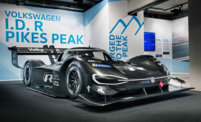 Volkswagen I.D. R Pikes Peak – η ηλεκτρική κατάκτηση της κορυφής • Η Volkswagen παρουσιάζει ένα ξεχωριστό super sports car: το I.D. R Pikes Peak • Η Volkswagen στοχεύει στην κατάρριψη του ρεκόρ στην κατηγορία των ηλεκτροκίνητων οχημάτων, στον περίφημο αγώνα του Pikes Peak • 680 ίπποι – 650 Nm ροπής, βάρος λιγότερο από 1.100 κιλά • Το I.D. R Pikes Peak επιταχύνει 0-100 σε μόλις 2,25 δευτερόλεπτα, ταχύτερο από Formula 1 & Formula E Μία νέα εποχή για τη Volkswagen στους αγώνες. Αποκαλύφθηκε το αμιγώς ηλεκτρικό της υπεραυτοκίνητο, το I.D. R Pikes Peak. Με ισχύ που φτάνει τους 680 ίππους (500kW), 650Nm ροπής, και βάρος που δεν ξεπερνά τα 1.100 κιλά, το συγκεκριμένο υπεραυτοκίνητο στις 24 Ιουνίου 2018 θα λάβει μέρος στην εμβληματική ανάβαση του Pikes Peak, στο Colorado Springs των ΗΠΑ. Στόχος της Volkswagen; Να σπάσει το ρεκόρ των 8΄ 57΄΄ 118 εκατοστών για ηλεκτρικά αυτοκίνητα, στον «Αγώνα προς τα Σύννεφα», (Race to the Cloud), όπως συμβολικά αποκαλείται. Για την επίτευξη του στόχου, το I.D. R Pikes Peak σίγουρα θα κάνει μία τεράστια εκτίναξη προς το μέλλον. Τόσο μεταφορικά όσο και ρεαλιστικά: τα 0-100 έρχονται σε μόλις 2,25 δευτερόλεπτα, επίδοση που αφήνει πίσω ακόμα και τα μονοθέσια της Formula 1 και της Formula E. Βασικός στόχος στην εξέλιξη του Volkswagen I.D. R Pikes Peak, ήταν η ιδανική ισορροπία μεταξύ αποθήκευσης ενέργειας και συνολικού βάρους. Σε αντίθεση με τα κοινά αγωνιστικά αυτοκίνητα, οι απόλυτες επιδόσεις δεν ήταν αυτοσκοπός. Τα ποιοτικά χαρακτηριστικά του πρωτότυπου της Volkswagen για το Pikes Peak, αναδεικνύονται ακόμα και από το όνομά του: To “R”, που έχει γίνει πλέον συνώνυμο των επιδόσεων, και το “I.D.” – που συμβολίζει τις ευφυείς ‘E-τεχνολογίες’ της Volkswagen. Όπως και με το εντυπωσιακό Golf με τους δύο κινητήρες που έλαβε μέρος στο Pikes Peak το 1985, 1986 και το 1987, έτσι και τώρα οι μηχανικοί επέλεξαν τη λύση των δύο κινητήριων συνόλων. Το I.D. R Pikes Peak διαθέτει δύο ηλεκτροκινητήρες, οι οποίοι εξασφαλίζουν στον αυτοκίνητο συνολική ισχύ που φτάνει τους 680 ίππους (500kW). Σε αναλογία με τα ηλεκτροκίνητα μοντέλα παραγωγής, ως βασική μονάδα αποθήκευσης ενέργειας επιλέχθηκε η λύση των συσσωρευτών ιόντων λιθίου. Οι απαιτήσεις από τις κυψέλες της μπαταρίας είναι τεράστιες. Η πυκνότητα ισχύος είναι κρίσιμος παράγοντας για το σύστημα, κατά την παραγωγή υψηλής τάσης. Σε αντίθεση όμως με τα μοντέλα μαζικής παραγωγής, όπου ο στόχος είναι η εξασφάλιση της μέγιστης δυνατής εμβέλειας, οι μηχανικοί της αγωνιστικής ομάδας επεδίωξαν να επιτύχουν την μέγιστη απόδοση ισχύος. Στα 20 χιλιόμετρα της ανάβασης, έχουμε παραγωγή σχεδόν του 20% της απαιτούμενης ηλεκτρικής ενέργειας όχι από τους συσσωρευτές αλλά από ανάκτηση ενέργειας: στη φάση του φρεναρίσματος, οι ηλεκτροκινητήρες, όπου σε αυτή την περίπτωση λειτουργούν ως γεννήτριες, μετατρέπουν σε ηλεκτρική ένα μέρος της ενέργειας πέδησης και τροφοδοτούν στη συνέχεια την μπαταρία. Από σήμερα ξεκινά για τη Volkswagen το πρόγραμμα δοκιμών. Και ειδικά οι δοκιμές είναι από τις πλέον ιδιότυπες προκλήσεις του Pikes Peak. Στη διαδρομή των 19,99 χιλιομέτρων της ανάβασης στο Colorado Springs οι δοκιμές είναι πολύ περιορισμένες και μόνο σε ορισμένα τμήματα. Για το λόγο αυτό, η πλειονότητά τους δεν γίνεται στην πραγματική διαδρομή, αλλά σε πίστα. Στο τιμόνι του Volkswagen I.D. R Pikes Peak, στην προσπάθεια κατάρριψης του ρεκόρ, θα βρεθεί ο κορυφαίος στον κόσμο οδηγός τέτοιων διαδρομών και τρεις φορές νικητής του Pikes Peak, ο Γάλλος Ρομαίν Ντυμά (Romain Dumas). Αυτή τη φορά, θα προσπαθήσει, στο τιμόνι του Volkswagen I.D. R Pikes Peak, να σπάσει το ρεκόρ της κατηγορίας των ηλεκτρικών αυτοκινήτων. Ο 39χρονος Γάλλος λατρεύει αυτό το είδος των προκλήσεων. Εκτός των 3 νικών στο Pikes Peak, έχει επίσης ανέβει και 2 φορές στο 1ο σκαλί του βάθρου στον 24ωρο αγώνα του Le Mans. Συμπτωματικά, ο Ντυμά, που έχει σαν πρότυπό του το θρύλο των αγώνων Τζάκυ Ιξ, έχει γεννηθεί στην Alès, την πόλη της Γαλλίας όπου βρίσκεται η πίστα όπου θα πραγματοποιηθούν οι δοκιμές του I.D. R Pikes Peak. Η μεγάλη μέρα είναι η 24η Ιουνίου 2018! Εκκίνηση σε υψόμετρο 2.862μ. από την επιφάνεια της θάλασσας, 1.440μ κάθετης ανάβασης, 156 στροφές, 100% άσφαλτος, και όλα αυτά σε ένα και μοναδικό πέρασμα, σε μία μόνον προσπάθεια. Για την κατάρριψη του ρεκόρ δεν αρκεί μόνο η τέλεια κατάσταση μηχανής και οδηγού, αλλά και ο ρόλος που θα διαδραματίσουν οι καιρικές συνθήκες. Δεν είναι σπάνιο φαινόμενο, στα 4.302μ. που βρίσκεται η κορυφή και ο τερματισμός του Pikes Peak, η θερμοκρασία να βρίσκεται κάτω από το μηδέν, ακόμα και το Ιούνιο.