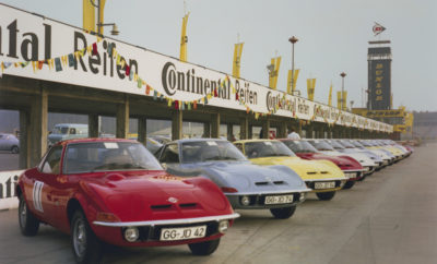 Επετειακό ‘Grand Tour’ με 75 πανέμορφα Opel GT Ο Παγκόσμιος Πρωταθλητής Walter Röhrl τέθηκε επικεφαλής με το προσωπικό του GT Ο σχεδιαστής GT Erhard Schnell, συνοδηγός του Röhrl Ο θρύλος των αγώνων Volker Strycek συμμετέχει με το δικό του GT 1900 Junior Για μία ώρα, το Hockenheimring έκανε ένα διάλειμμα από την καθημερινή του ρουτίνα. Οι ομάδες δοκιμών με τις αγωνιστικές φόρμουλες και τα αυτοκίνητα τουρισμού άφησαν για λίγο τα ‘εργαλεία’ τους και παρατάχθηκαν κατά μήκος του τοίχου των pits για να απολαύσουν το θέαμα: 75 αναλλοίωτα στο χρόνο Opel GT από όλη την Ευρώπη να διασχίζουν με μεγάλη ταχύτητα τη γραμμή εκκίνησης μέχρι τον τερματισμό. Η Opel Classic έφερε το αρχαιότερο GT από το 1968 ("το Νο 1") και το νεότερο από το 1973. Επικεφαλής τέθηκε Walter Röhrl, παγκόσμιος πρωταθλητής ράλι το 1982 με ένα Opel Ascona 400 και με συνοδηγό τον σχεδιαστή του GT, Erhard Schnell. Οι δυο τους κάθισαν στο προσωπικό, ασημί Opel GT του Röhrl. Ο αγωνιστικός θρύλος της Opel Volker Strycek ήταν επίσης εκεί, με το δικό του Opel GT Junior με σπάνιες εκδόσεις (tuning) των βελτιωτικών οίκων Irmscher και Conrero να αποτελούν ξεχωριστές παρουσίες . Όλοι τους ήταν και είναι τμήμα του Grand Tour, που διοργανώνεται από το Σύνδεσμο Ευρωπαϊκών Λεσχών GT μεταξύ 19 και 22 Σεπτεμβρίου. Ο τελικός θα πραγματοποιηθεί το Σάββατο στο Κέντρο Δοκιμών της Opel στο Dudenhofen. Οι ‘γρήγοροι’ γύροι στο Hockenheimring έγιναν προς τιμήν των 50 χρόνων του Opel GT. Σχεδόν πριν από 50 χρόνια, 21 – 29 Οκτωβρίου 1968 για να ακριβολογούμε, η Opel πραγματοποίησε τα GT test days στην αγωνιστική πίστα. Στο πλαίσιο της παρουσίασης, 41 Opel GT 1100 και Opel GT 1900 καθώς και 44 ακόμη σπορ μοντέλα από το Rallye Kadett μέχρι το Commodore GS βρέθηκαν εκεί. Δημοσιογράφοι, διανομείς, σύμβουλοι πωλήσεων, πελάτες και οδηγοί αγώνων είχαν την ευκαιρία να απολαύσουν οι ίδιοι τα ταλέντα του αυτοκινήτου. Και επιβεβαιώνοντας το διαφημιστικό μήνυμα "Only flying is more beautiful" (μόνο η πτήση είναι ομορφότερη) οι Σουηδοί οδηγοί ράλι Lillebror Nasenius (Ευρωπαίος πρωταθλητής 1966 με ένα Opel Rekord) και Sylvia Österberg έδειξαν τι μπορούσε να κάνει το νέο σπορ αυτοκίνητο από το Rüsselsheim – ακόμα και άλματα! Πενήντα χρόνια αργότερα, ο δύο φορές Παγκόσμιος Πρωταθλητής Ράλι Walter Röhrl οδήγησε το δικό του Opel GT στο Hockenheimring με μοναδική ακρίβεια. Ο τελειομανής οδηγός αγόρασε το Opel GT του από έναν φίλο ζωής. Ο Herbert Fabian εξασφάλισε τον δεύτερο παγκόσμιο τίτλο για τον Röhrl το 1982, όταν ο αρχιμηχανικός της Opel τοποθέτησε ένα νέο πίσω άξονα στο Ascona 400 εν μια νυκτί στο Ivory Coast Rally. Ο Röhrl με συνοδηγό τον Christian Geistdörfer, κέρδισαν στο ράλι και κατέκτησαν το παγκόσμιο πρωτάθλημα. Το 2016, ο Walter Röhrl επισκέφθηκε τον φίλο του για τα γενέθλιά του στο Trebur, Hesse. Ο Fabian του έδειξε ένα ασημί GT σε άριστη κατάσταση και είπε στον Röhrl ότι έκανε αναπαλαίωση στο coupé πάνω από δέκα χρόνια, αλλά τώρα ήταν πολύ δύσκολο να ‘χωρέσει’ στο στενό σπορ κάθισμα. «Τότε λοιπόν πούλησέ το σε μένα» απάντησε ο δύο φορές Παγκόσμιος Πρωταθλητής Ράλι αυθόρμητα. «Ήθελα το GT για τρεις λόγους» εξηγεί ο Röhrl στο Hockenheim. «Ο πρώτος είναι ότι στα νιάτα μου, όλοι, συμπεριλαμβανομένου και εμού, ονειρεύονταν από το αυτοκίνητο. Και κατά δεύτερο, το αυτοκίνητο μου θυμίζει τις στιγμές και τις επιτυχίες μου με την Opel, αλλά και την φιλία μου με το Herbert Fabian.» Κατά τη διάρκεια του Grand Tour, ο Walter Röhrl συναντήθηκε επίσης με τον δημιουργό του μοναδικού σχήματος του GT, Erhard Schnell, για πρώτη φορά. Ο σχεδιαστής παραμένει λάτρης του δημιουργήματός του ακόμα και στην ηλικία των 91 ετών. «Οι αντιδράσεις ήταν τεράστιες το 1968, αλλά σήμερα, νιώθω ότι το GT είναι ακόμα πιο αξιαγάπητο» δήλωσε. Ο Schnell ανέλαβε χρέη συνοδηγού του Walter Röhrl στο Hockenheim. Επιστρέφοντας στο paddock, ο Röhrl είχε μία ιδέα: ζήτησε από τον Schnell να υπογράψει το GT του σε έναν από τους θρυλικούς, αναδιπλούμενους προβολείς. Είναι η πρώτη φορά που ο Röhrl ζητά από κάποιον αυτόγραφο. Grand Tour 2018: Επιφανείς οδηγοί και γρήγορα Opel GT Όσοι έχουν κάποια σχέση με το Opel GT έσπευσαν να συμμετάσχουν στις εορταστικές εκδηλώσεις του Hockenheim: Ο πρόεδρος της Αμερικανικής Λέσχης GT, Gil Wesson, πέταξε από την άλλη πλευρά του Ατλαντικού. Είχε ήδη οργανώσει ένα οκταήμερο επετειακό οδοιπορικό στη θρυλική Route 66 νωρίτερα μέσα στη χρονιά. Διευθυντής του Grand Tour, ωστόσο, είναι ο Olaf Moldzen. Ο Γερμανός ηγείται της Ευρωπαϊκής Ομοσπονδίας Λεσχών Opel GT. Αυτή περιλαμβάνει προς το παρόν 28 λέσχες με περίπου 1.450 μέλη και 1.550 οχήματα. Ο Moldzen βρίσκεται επίσης στο Hockenheim με το GT 1900 του 1969 – ένα αυτοκίνητο τουρισμού της Irmscher. Μιλώντας για αγωνιστικά αυτοκίνητα: εκτός από ένα δεύτερο, πρόσφατα ανακατασκευασμένο coupé από τον βελτιωτή της Opel Irmscher, υπάρχει και ένα Conrero GT στη πίστα. Το αγωνιστικό από την Ιταλία ήταν ο ήρωας του 1971 Targa Florio, όπου απέκρουσε τον ισχυρότερο ανταγωνισμό από την Porsche. Τέλος, το πορτοκαλί GT 1900 Junior ιδιοκτησίας Volker Strycek κλέβει την παράσταση. ‘Only flying is more beautiful’: ένα αυτοκίνητο, δύο κινητήρες ένα πραγματικό dream car Το 1968, το πρώτο Opel GT πέρασε από τη γραμμή παραγωγής, μετά από σχολαστική αξιολόγηση και έλεγχο στο τότε νέο Κέντρο Δοκιμών της Opel στο Dudenhofen. Το σπορ coupé ήταν προϊόν μιας Γαλλο-Γερμανικής συνεργασίας και επομένως, γνήσιο Ευρωπαϊκό: οι Γάλλοι κατασκευαστές αμαξωμάτων Chausson και Brissoneau & Lotz, γνωστοί στην Opel λόγω προηγούμενων projects, ανέλαβαν τα πρεσαριστά πάνελ αμαξώματος, τη συγκόλληση, τη βαφή και την εγκατάσταση του εξοπλισμού εσωτερικού του GT, πριν σταλεί στη Γερμανία για τελική συναρμολόγηση του πλαισίου και του κινητήρα. Οι πελάτες GT μπορούσαν να επιλέξουν από δύο κινητήρες: ένα διάσημο 1.1L τετρακύλινδρο με 60 hp από την οικογένεια Kadett και έναν 1.9L (90-hp) από το Rekord. Το GT 1900 είχε μεγάλη ζήτηση από την πρώτη στιγμή. Με τελική ταχύτητα 185 km/h και επιτάχυνση 0 - 100 km/h σε 11,5 δευτερόλεπτα, έκανε την καρδιά των οδηγών να χτυπά σε αγωνιστικούς ρυθμούς. Ένα μηχανικό, τετρατάχυτο κιβώτιο υψηλής ακρίβειας ήταν στάνταρ εξοπλισμός. Το προαιρετικό, αυτόματο τριών σχέσεων δεν είχε ιδιαίτερο ενδιαφέρον για τους Ευρωπαίους πελάτες, αλλά ήταν πολύ δημοφιλές στις ΗΠΑ. Σχεδόν το 70% από τα 103.463 GT που κατασκευάστηκαν βρήκαν εκεί τους αγοραστές τους. Εν τω μεταξύ, πολλά από αυτά τα οχήματα που πουλήθηκαν εκεί, επιστρέφουν τώρα στην Ευρώπη, μερικά μάλιστα γιορτάζουν την 50ή επέτειο του Opel GT – στο Grand Tour 2018.