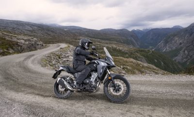 Η CB500X – που παρουσιάστηκε για πρώτη φορά το 2013 μαζί με τη ‘γυμνή’ CB500F και τη CBR500R με το ολόσωμο φέρινγκ – φέρνει ένα crossover adventure στυλ στην τριμελή οικογένεια απολαυστικών δικύλινδρων μοτοσυκλετών Honda μεσαίας κατηγορίας. Χωρίς φανφάρες, κάνει αθόρυβα τη δουλειά της, ενώ είναι εξαιρετικά ικανή και ευπροσάρμοστη στις επιθυμίες του ιδιοκτήτη. Η πρακτικότητα της CB500X βασίζεται σε μια έντιμη εξίσωση – ένας ζωηρός, αποδοτικός δικύλινδρος κινητήρας που αποδίδει πλούσια ροπή και ισχύ από τις χαμηλές στροφές (και επιταχύνει δυναμικά μέχρι την κόκκινη περιοχή του στροφόμετρου) – και ένα πλαίσιο που χαρίζει εξαιρετική οδηγική άνεση στην πόλη αλλά και στον αυτοκινητόδρομο. Στην ελληνική αγορά η νέα CB500X είναι διαθέσιμη μέσα από το Δίκτυο των Επισήμων Εμπόρων της εταιρείας Αδελφοί Σαρακάκη Α.Ε.Β.Μ.Ε. , Επίσημος Εισαγωγέας-Διανομέας Honda Moto στην Ελλάδα στην τιμή των 7,200€. Πολυτάλαντη, κινείται άνετα σε μικρές καθημερινές διαδρομές πόλης, αλλά και στις εκδρομές του Σαββατοκύριακου. Η μεγάλη διαδρομή των αναρτήσεων εξομαλύνει τις ανωμαλίες, ενώ το φαρδύ τιμόνι και η όρθια θέση οδήγησης προσφέρουν άνεση και ορατότητα στον αναβάτη. Με άλλα λόγια, η CB500X είναι πραγματικό all-rounder από κάθε άποψη. Το 2016, στην πρώτη αναβάθμιση, η CB500X απέκτησε μεγαλύτερο ρεζερβουάρ καυσίμου, αυξημένη προστασία από τον αέρα και ψηλότερη ζελατίνα. Επίσης, απέκτησε φώτα LED, ρυθμιζόμενη προ-φόρτιση πιρουνιού και ρυθμιζόμενη μανέτα φρένου. Το 2019, επεφύλασσε μία σημαντική εξέλιξη για την CB500X. Πιο προηγμένο adventure στυλ, που υπογραμμίζει και επιβεβαιώνει τη μοναδικότητά της. Αν και οι βελτιωμένες επιδόσεις του κινητήρα και οι αναβαθμίσεις πλαισίου εξασφαλίζουν τη διατήρηση του πολυδιάστατου χαρακτήρα της, ο παράγοντας ‘X’ έχει ενισχυθεί αισθητά. 2. Επισκόπηση Μοντέλου Από μοτοσυκλέτα για καθημερινές διαδρομές στην πόλη μέχρι τις περιπέτειες του Σαββατοκύριακου – η 2019 CB500X είναι έτοιμη για όλα. Το στυλ της για το 2019 γίνεται πιο αιχμηρό – με πιο έντονο το adventure στοιχείο και επιρροές από την Africa Twin, στο οποίο προστίθεται η μεγαλύτερη διαδρομή της ανάρτησης, το μονό αμορτισέρ υψηλών προδιαγραφών, η βελτιωμένη εργονομία και ο εμπρός τροχός 19 ιντσών. Και ενώ ο κινητήρας της CB500X διατηρεί τα 35kW που απαιτούνται για κατόχους άδειας A2, αποδίδει τώρα 4% περισσότερη ισχύ και ροπή μεταξύ 3-7.000rpm, χάρη στις αναβαθμίσεις στην εισαγωγή, την εξαγωγή και το χρονισμό των βαλβίδων. Το νέο τελικό εξάτμισης με δύο απολήξεις βγάζει ένα βελτιωμένο, μπάσο ήχο, ενώ ο κινητήρας συνεργάζεται με ένα μονόδρομο συμπλέκτη assist/slipper. Νέα όργανα LCD περιλαμβάνουν μία νέα λειτουργία Shift Up και Gear Position ενώ οι ενδείξεις είναι τώρα LED, σε αρμονία με τον υπόλοιπο φωτισμό. 3. Κύρια Χαρακτηριστικά 3.1 Στυλ & Πλαίσιο • Ισχυρότερο, πιο σκληροτράχηλο adventure στυλ • Νέο κωνικό τιμόνι που στρίβει ακόμα περισσότερο • Μεγαλύτερη διαδρομή ανάρτησης και εμπρός τροχός 19 ιντσών • Νέα οθόνη LCD, με ενδείξεις Gear Position και Shift Up • Φλας LED Η 2019 CB500X ξαναγεννήθηκε με πιο επιθετικό στυλ adventure, ‘έτοιμη για την άγρια φύση’. Με ‘πιλότο’ την δημοφιλή CRF1000L Africa Twin, οι μηχανικοί εξέλιξης της Honda επέκτειναν τα προστατευτικά του ψυγείου και το φέρινγκ με περισσότερες γωνίες για πιο 3D εμφάνιση και αίσθηση, ενώ το ρεζερβουάρ καυσίμου επικαλύπτεται από τα πλαϊνά καλύμματα, σαν ένας συνεκτικός κρίκος του εμπρός και πίσω τμήματος της μοτοσυκλέτας. Μπορεί μεν η CB500X να έχει ωριμάσει, ωστόσο η φετινή ανανέωση δεν εξυπηρετεί μόνον αισθητικούς σκοπούς. Χάρη στη βελτιωμένη αεροδυναμική, ο αέρας που διέρχεται με υψηλή πίεση από το φέρινγκ και τη ζελατίνα, έχει μειωθεί, βελτιώνοντας την προστασία του αναβάτη από τον αέρα σε μεγάλες ταχύτητες. Το προφίλ της σέλας έχει επίσης λεπτύνει στο εμπρός τμήμα, βελτιώνοντας τον έλεγχο και τη μετατόπιση του σώματος, ενώ διευκολύνει τους αναβάτες να φτάσουν τα πόδια τους στο έδαφος. Για μεγαλύτερη ευελιξία της CB500X, το τιμόνι περιστρέφεται περισσότερο κατά 3 μοίρες (38° από το κέντρο), ενώ η προσθήκη ενός gunmetal grey κωνικού ατσάλινου τιμονιού βελτιώνει περαιτέρω τον έλεγχο. Η νέα οθόνη LCD – που εδράζεται σε ένα ταμπλό με πολλαπλές επιφάνειες και υλικά - απηχεί το συνολικό σχεδιαστικό θέμα, ενώ περιλαμβάνει δείκτη Gear Position και Shift Up που είναι ρυθμισμένος στάνταρ στις 8.750rpm, αλλά μπορεί να ρυθμιστεί σε στάδια των 250rpm μεταξύ 5-8.750rpm. Η σωληνωτή βάση της οθόνης μπορεί επίσης να φιλοξενήσει ένα GPS πάνω από τα όργανα. Το ατσάλινο πλαίσιο - διαμάντι με σωλήνα διατομής 35mm παραμένει ίδιο για το 2019. Είναι ελαφρύ και πανίσχυρο αλλά με ελεγχόμενη ακαμψία που μεταφέρει πληροφορία στον αναβάτη από το οδόστρωμα. Το σχήμα και η τοποθέτηση των βάσεων του κινητήρα σε συνδυασμό με τη στρεπτική ακαμψία του πλαισίου περιορίζουν τους κραδασμούς. Το μεταξόνιο είναι 1445mm με γωνία κάστερ και ίχνος τροχού 27.5 και 108mm αντίστοιχα, για ευέλικτη συμπεριφορά που εμπνέει εμπιστοσύνη. Η συσσώρευση της μάζας στο κέντρο με τον κινητήρα πολύ κοντά στο σημείο περιστροφής του ψαλιδιού, συνεπάγεται ευελιξία και ιδανική κατανομή του βάρους εμπρός - πίσω, που επίσης εξασφαλίζει σταθερότητα. Το βάρος πλήρως υγρών είναι 197kg. Το ύψος της σέλας είναι 830mm και οι συνολικές διαστάσεις 2155mm x 825mm x 1410mm, με απόσταση από το έδαφος 180mm. Η χωρητικότητα του ρεζερβουάρ είναι 17,5L μαζί με τη ρεζέρβα και με δεδομένη την εξαιρετική κατανάλωση των 27,8km/l (**mpg) (WMTC mode) προσφέρει αυτονομία 500km. Το τηλεσκοπικό πιρούνι των 41 mm με ρύθμιση προ-φόρτισης προσφέρει επιπλέον διαδρομή 10mm, φτάνοντας τα 150mm. Η διαδρομή στον πίσω τροχό έχει αυξηθεί από 118m σε 135mm και ένα νέο, μονοσωλήνιο πίσω αμορτισέρ (ανάλογο αυτών που συναντάμε σε σπορ μοτοσυκλέτες μεγαλύτερου κυβισμού) αντικαθιστά τη δισωλήνια σχεδίαση του προηγούμενου μοντέλου. Το μεγάλης διαμέτρου έμβολο εξασφαλίζει άριστη απόκριση της ανάρτησης και διαχείριση θερμοκρασίας. Η CB500X έχει τώρα ρύθμιση προ-φόρτισης ελατηρίου 9 σταδίων και συνεργάζεται με ένα άκαμπτο, ατσάλινο Pro-Link ψαλίδι τετραγωνικής διατομής, που τώρα περιλαμβάνει πρεσαριστό, ατσάλινο ρεγουλατόρο αλυσίδας. Η τελική μετάδοση είναι με «αυτολιπαινόμενη» αλυσίδα 520. Ο εμπρός τροχός 17” έχει αντικατασταθεί από ένα 19” – με μεγαλύτερη διαδρομή ανάρτησης – και εξασφαλίζει αξιόπιστη, εξαιρετικά σταθερή συμπεριφορά σε κακοτράχαλα εδάφη. Ο ελαφρύς αλουμινένιος τροχός συνδυάζεται με ελαστικό 110/80-R19 με πέλμα τύπου On-off, ενώ ο πίσω τροχός 17” φορά ελαστικό160/60-R17. Ένας μονός κυματιστός δίσκος 320 mm εμπρός με διπίστονη δαγκάνα συνδυάζεται με πίσω δίσκο 240 mm και μονοπίστονη δαγκάνα. ABS προσφέρεται στάνταρ. Η CB500X θα διατίθεται με τις εξής χρωματικές επιλογές: Grand Prix Red Matt Gunpowder Black Metallic Pearl Metalloid White 3.2 Κινητήρας • Η εσωτερική δομή του ζωηρού δικύλινδρου κινητήρα αντιγράφει την αντίστοιχη της CBR1000RR Fireblade • Αναβάθμιση εισαγωγής, εξαγωγής και χρονισμού βαλβίδων για 4% περισσότερη ισχύ και ροπή στη μεσαία κλίμακα στροφών • Πιο σπορ ήχος από το νέο τελικό εξάτμισης δύο απολήξεων • Μονόδρομος συμπλέκτης Assist/Slipper κάνει ευκολότερα τα ανεβάσματα και διαχειρίζεται τα κατεβάσματα Η διάταξη του οκταβάλβιδου, υγρόψυκτου, παράλληλου δικύλινδρου κινητήρα της CB500X, κατάλληλη και για κατόχους διπλώματος Α2, προσφέρει μία ισορροπία φυσικού μεγέθους και άμεσης, απολαυστικής ισχύος, με ζωηρό, υψηλόστροφο χαρακτήρα και απολαυστική μέγιστη ισχύ. Ήδη ισχυρός από τις χαμηλές στροφές, ο στόχος εξέλιξης για το 2019 ήταν ταχύτερη επιτάχυνση με μία αύξηση ισχύος και ροπής στις χαμηλές και μεσαίες στροφές στην κλίμακα 3-7,000rpm. Η βελτίωση της τάξεως του 4% έχει επιτευχθεί με μία αλλαγή στο χρονισμό των βαλβίδων – με το χρονισμό κλεισίματος να επιταχύνεται κατά 5° – και τη βύθιση να αυξάνεται κατά 0,3mm στα 7,8mm. Η εισαγωγή αέρα για το σύστημα ψεκασμού καυσίμου PGM-FI είναι σχεδόν μια ευθεία από το φιλτροκούτι και μέσω των πεταλούδων γκαζιού. Η μπαταρία επανατοποθετήθηκε πιο μακριά (44,1mm αντί 13,4mm) από το φιλτροκούτι για να επιτρέπει καλύτερη ροή αέρα. Το σιλανσιέ φέρει τώρα δύο απολήξεις εξαγωγής, προσθέτοντας πιο σπορ χροιά σε κάθε παλμό και εμφάνιση. Η μέγιστη ισχύς των 35kW επιτυγχάνεται στις 8.500rpm, και η ροπή των 43Nm στις 7.000rpm. Η διάμετρος και η διαδρομή του εμβόλου είναι 67mm x 66,8mm, η σχέση συμπίεσης παραμένει 10.7:1, τα κομβία του στροφαλοφόρου έχουν μεταξύ τους γωνία 180° και ο αντικραδασμικός άξονας τοποθετείται πίσω από τους κυλίνδρους, κοντά στο κέντρο βάρους της μοτοσυκλέτας. Για την πρωτεύουσα μετάδοση και τον αντικραδασμικό άξονα χρησιμοποιούνται ψαλιδωτά γρανάζια για τον περιορισμό του θορύβου. Τα αντίβαρα του στροφάλου είναι σχεδιασμένα για ομαλή λειτουργία και το χαμηλό του βάρος επιτρέπει στον κινητήρα να ανεβάζει εύκολα στροφές, με περιορισμένη αδράνεια. Ο ίδιος ο κινητήρας λειτουργεί ως ενεργό τμήμα του πλαισίου, ενισχύοντας την ακαμψία του με τέσσερις βάσεις στην κυλινδροκεφαλή. Εσωτερικά, η κυλινδροκεφαλή χρησιμοποιεί κοκοράκια με ρόλερ. Η ρύθμιση βαλβίδων με καπελότα μειώνει το βάρος, τα φορτία και τις τριβές. Μία αθόρυβη καδένα (SV Chain) έχει επικάλυψη βαναδίου στους πείρους της, για μείωση των τριβών και αυξημένη προστασία από τη φθορά. Η διάμετρος των βαλβίδων εισαγωγής είναι 26.0mm και εξαγωγής 21.5mm. Το σχήμα του εμβόλου βασίστηκε σε αυτό της CBR1000RR Fireblade, ώστε να μειωθεί ο ‘θόρυβος’ στις υψηλές στροφές. Οι εσωτερικές τριβές έχουν περιοριστεί με την προσθήκη ραβδώσεων στο κάτω μέρος του εμβόλου (μία μέθοδος που αυξάνει την επιφάνεια επαφής, εισάγοντας διάκενα στα οποία ρέει το λάδι, για καλύτερη λίπανση). Όπως και στην CBR1000RR, μία διαδικασία εμβάπτισης σε άλας ΑΒ1, που χρησιμοποιείται μετά την εναζώτωση Isonite, δημιουργεί μία προστατευτική, οξειδωτική μεμβράνη. Η τριγωνική διάταξη στροφαλοφόρου, πρωτεύοντα άξονα και αντικραδασμικού άξονα είναι παρόμοια με εκείνη των τετρακύλινδρων κινητήρων RR της Honda, ενώ σχεδιαστικά και λειτουργικά βασίζεται στη φιλοσοφία της CBR1000RR. Ο μονομπλόκ στροφαλοθάλαμος χρησιμοποιεί φυγοκεντρικά χυτευμένα, λεπτά χιτώνια. Ιδιαίτερη προσοχή έχει δοθεί στον εσωτερικό του σχεδιασμό, με στόχο τον περιορισμό των απωλειών ‘άντλησης’ που μπορεί να προκαλούνται με σειρά ανάφλεξης 180°. Χρησιμοποιώντας την ίδια υποδομή εκτόνωσης με της CBR1000RR, η αντλία λαδιού παρουσιάζει βελτιωμένη απόδοση εξαερισμού, με περιορισμένες τριβές. Ένα βαθύ κάρτερ μειώνει την κίνηση του λαδιού σε έντονο στρίψιμο και φρενάρισμα. Η χωρητικότητα σε λιπαντικό είναι 3,2L. Το εξάρι κιβώτιο είναι όμοιο με αυτό των RR της οικογένειας. Διαθέτει τον ίδιο λεβιέ και μοχλικό. Νέος για το 2019, ένας μονόδρομος συμπλέκτης Assist/Slipper επιτρέπει πιο εύκολα ανεβάσματα και εξομαλύνει τα απότομα κατεβάσματα. 4. Αξεσουάρ Μία πλούσια γκάμα Γνήσιων Αξεσουάρ Honda διατίθεται για την CB500X. Μεταξύ αυτών Κεντρικό σταντ Προστατευτικά αέρα (εκτροπείς) Χούφτες Θερμαινόμενα γκριπ Top box 35L Πίσω σχάρα Βάσεις για πλαϊνές μπαγκαζιέρες Πλαϊνές μπαγκαζιέρες Κάγκελα Φώτα ομίχλης Τσάντα ρεζερβουάρ Τσάντα σέλας Πρίζα φόρτισης ACC Φιμέ ζελατίνα Αυτοκόλλητα τροχών Προστατευτικό ρεζερβουάρ 5. Τεχνικά Χαρακτηριστικά ΚΙΝΗΤΗΡΑΣ Τύπος Υγρόψυκτος, παράλληλος, δικύλινδρος Κυβισμός (cm³) 471cc Διάμετρος x Διαδρομή (mm) 67mm x 66.8mm Σχέση συμπίεσης 10.7 : 1 Μέγιστη Ισχύς 47,6hp (35kW) @ 8600rpm Μέγιστη Ροπή 43Nm @ 6500rpm Χωρητικότητα σε λιπαντικό 3.2L ΣΥΣΤΗΜΑ ΤΡΟΦΟΔΟΣΙΑΣ Ψεκασμός καυσίμου PGM FI Χωρητικότητα ρεζερβουάρ 17.7L (συμπερ. ρεζέρβας) Κατανάλωση (WMTC) 27.8/litre ΗΛΕΚΤΡΙΚΟ ΣΥΣΤΗΜΑ Χωρητικότητα μπαταρίας 12V 7.4AH Ισχύς ACG 25A/2000rpm ΜΕΤΑΔΟΣΗ Συμπλέκτης Υγρός πολύδισμος Κιβώτιο 6 τάχυτο Τελική μετάδοση Αλυσίδα ΣΚΕΛΕΤΟΣ Τύπος Ατσάλινο, τύπου διαμάντι ΠΛΑΙΣΙΟ Διαστάσεις (ΜxΠxΥ) 2155mm x 825mm x 1410mm (Χαμηλή ζελατίνα) 1445mm (Ψηλή ζελατίνα) Μεταξόνιο 1445mm Γωνία Κάστερ 27.5 μοίρες Ίχνος τροχού 108mm Ύψος Σέλας 830mm Απόσταση από έδαφος 180mm Βάρος (γεμάτη) 197kg ΑΝΑΡΤΗΣΗ Εμπρός Συμβατικό, τηλεσκοπικό εμπρός πιρούνι, 41mm, ρυθμιζόμενη προ-φόρτιση Πίσω Prolink mono με ρύθμιση προ-φόρτισης 5 σταδίων, ατσάλινο ψαλίδι τετραγωνικής διατομής ΤΡΟΧΟΙ Τροχός Εμπρός Πολύμπρατση, από χυτό αλουμίνιο Τροχός Πίσω Πολύμπρατση, από χυτό αλουμίνιο Διάσταση Τροχού Εμπρός 19 X MT2.5 Διάσταση Τροχού Πίσω 17 X MT4.5 Ελαστικό Εμπρός 110/80R19M/C (πέλμα On-off) Ελαστικό Πίσω 160/60R17M/C (πέλμα On-off) ΦΡΕΝΑ ABS 2κάναλο Εμπρός Μονός κυματοειδής δίσκος, 310mm, 2 πίστονη δαγκάνα Πίσω Μονός κυματοειδής δίσκος, 240mm, 1 πίστονη δαγκάνα ΟΡΓΑΝΑ & ΗΛΕΚΤΡΙΚΑ Όργανα Ψηφιακό ταχύμετρο, ψηφιακή μπάρα στο στροφόμετρο, διπλός χιλιομετρητής, ψηφιακός δείκτης στάθμης και κατανάλωσης καυσίμου, ψηφιακό ρολόι, ένδειξη σχέσης κιβωτίου Σύστημα Προστασίας HISS (Honda Intelligent Security System) Προβολέας Low 4.8W, Hi 12W Όλες οι προδιαγραφές είναι προσωρινές και υπόκεινται σε τροποποιήσεις χωρίς προειδοποίηση.