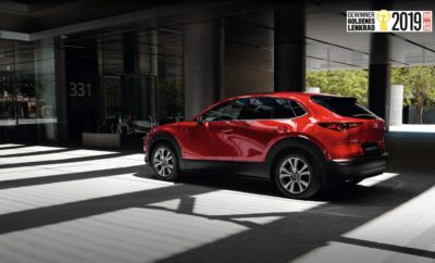 Το Mazda CX-30 είναι ο νικητής του βραβείου ‘Golden Steering Wheel’ για το 2019, επικρατώντας των ανταγωνιστών του στην κατηγορία SUV/crossover για οχήματα με μήκος έως 4,4μέτρα. Το ολοκαίνουργιο μικρομεσαίο SUV κερδίζει έτσι το πρώτο του βραβείο σε έναν από τους σημαντικότερους διαγωνισμούς επιλογής αναγνωστών της αυτοκινητοβιομηχανίας. Το βραβείο παρέλαβε ο πρόεδρος της Mazda Motor Europe, Yasuhiro Aoyama σε εκδήλωση που πραγματοποιήθηκε πριν λίγες μέρες στο Βερολίνο. Πρόκειται για το 5ο βραβείο του θεσμού Golden Steering Wheel που κατακτά μέχρι σήμερα η Mazda: Το Mazda 323 το 1985 και το 1989, το Mazda 626 το 1992, και το Mazda2 το 2014. Ο πρόεδρος Aoyama δήλωσε ενθουσιασμένος στην τελετή απονομής: “Είμαι ιδιαίτερα περήφανος που λαμβάνω σήμερα στο Βερολίνο αυτό το εξαιρετικό βραβείο για το νέο Mazda CX-30. Αυτό αποδεικνύει ότι βρισκόμαστε στο σωστό δρόμο, εστιάζοντας στο design, την τεχνολογική καινοτομία και την αρμονία μεταξύ οδηγού και αυτοκινήτου”. Εκτός από συγκεκριμένο βραβείο, η Mazda πανηγυρίζει επίσης και για το νέο κινητήρα Skyactiv-X αλλά και για το Mazda3, που βρέθηκαν ανάμεσα στα τρία πρώτα στις κατηγορίες της καινοτομίας και των μικρομεσαίων οχημάτων αντίστοιχα. “Με τον Skyactiv-X, η Mazda προσφέρει τον πρώτο κινητήρα μαζικής παραγωγής στον κόσμο, που χρησιμοποιεί τεχνολογία αυτανάφλεξης με συμπίεση όπως ένας diesel και τη χρήση μπουζί. Το γεγονός ότι η τεχνολογία αυτή ψηφίστηκε από τους αναγνώστες σαν μία από τις κορυφαίες καινοτομίες στη Γερμανία, μας δίνει μια θετική προοπτική για το μέλλον” προσθέτει ο πρόεδρος Aoyama. Ο διαγωνισμός ‘Golden Steering Wheel’, που πραγματοποιήθηκε για 43η χρονιά, βραβεύει κάθε χρόνο τις καλύτερες καινοτομίες στην αυτοκινητοβιομηχανία. Οι αναγνώστες της εφημερίδας Bild am Sonntag και του περιοδικού Auto Bild, επιλέγουν το καλύτερο από 7 κατηγορίες ανάμεσα από 58 υποψηφία μοντέλα, και ψηφίζουν επίσης για το «Πιο όμορφο αυτοκίνητο» και την «καινοτομία της χρονιάς». Τα μοντέλα που καταλαμβάνουν τις τρείς πρώτες θέσεις σε κάθε κατηγορία, οδηγούνται στην πίστα του Lausitzring τον Οκτώβριο. Η επιτροπή που απαρτίζονταν από 14 οδηγούς αγώνων και ειδικούς του χώρου επέλεξε το Mazda CX-30 μπροστά από το Volkswagen T-Cross και το Range Rover Evoque. Το ολοκαίνουργιο crossover παρουσιάστηκε για πρώτη φορά στη διεθνή έκθεση αυτοκινήτου της Γενεύης του 2019. Το μοντέλο τοποθετείται ανάμεσα στο Mazda CX-3 και το Mazda CX-5, και είναι σχεδιασμένο για τους πελάτες που αναζητούν το συνδυασμό ενός μικρομεσαίου οχήματος με ιδανικές διαστάσεις για την πόλη, με μεγάλους εσωτερικούς χώρους, πρακτικότητα και πρωτοποριακή τεχνολογία κινητήρα. Το Mazda CX-30 είναι διαθέσιμο με κινητήρες Skyactiv diesel και βενζίνης, αλλά και με τον νέο κινητήρα βενζίνης Skyactiv-X.